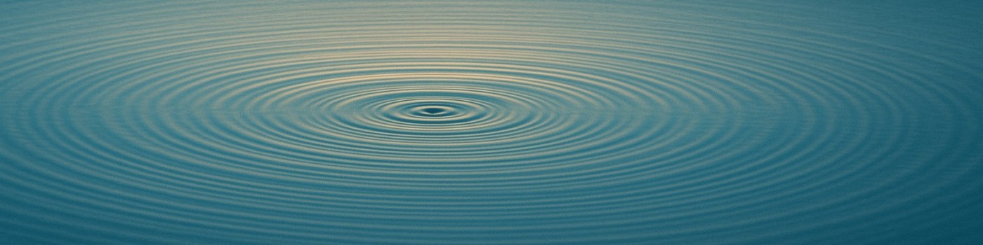 Concentric ripples spreading across calm sea-blue water